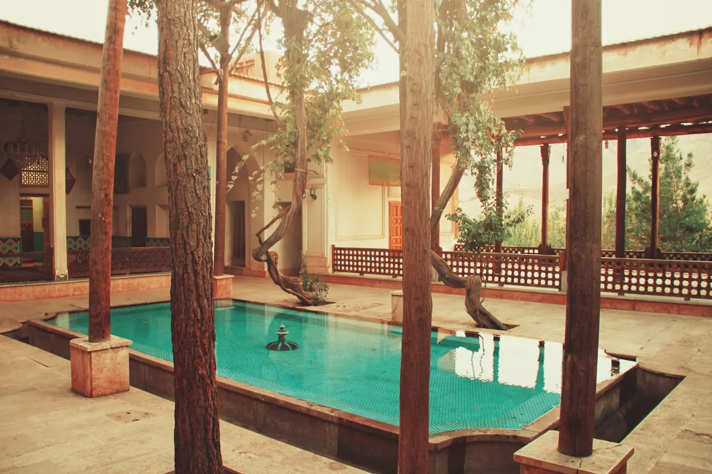 Boutique hotel courtyard with a swimming pool framed by trees